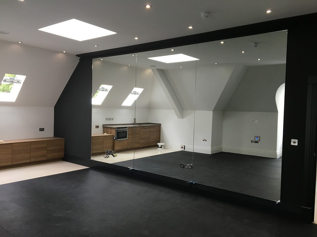 Frameless glass wall dividing loft conversion in Hampstead