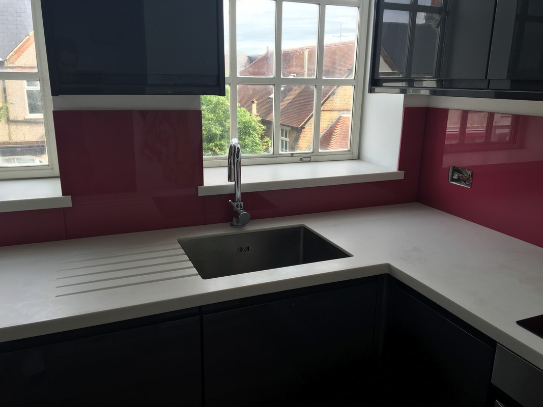Deep plum coloured glass splashback in modern Hampstead kitchen